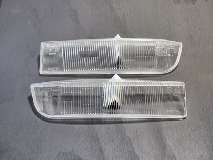 A set of two clear front fog lenses for a Ferrari Testarossa.